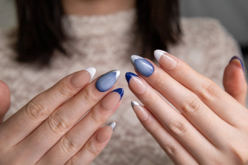 Blue Haze navy blue and white French tip press-on nails with silver cat-eye accent on hand