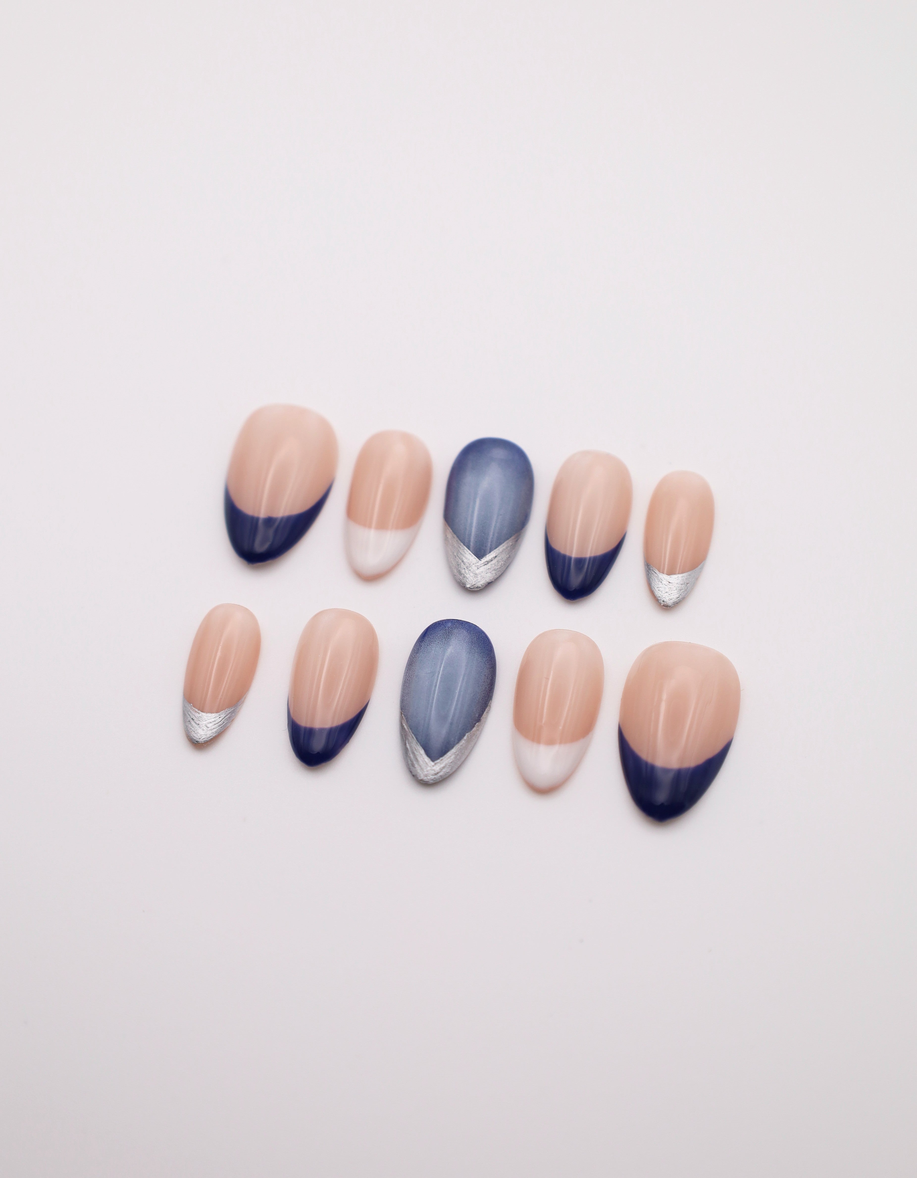 Blue Haze navy white French tip almond press-on nails set with metallic silver accent flatlay