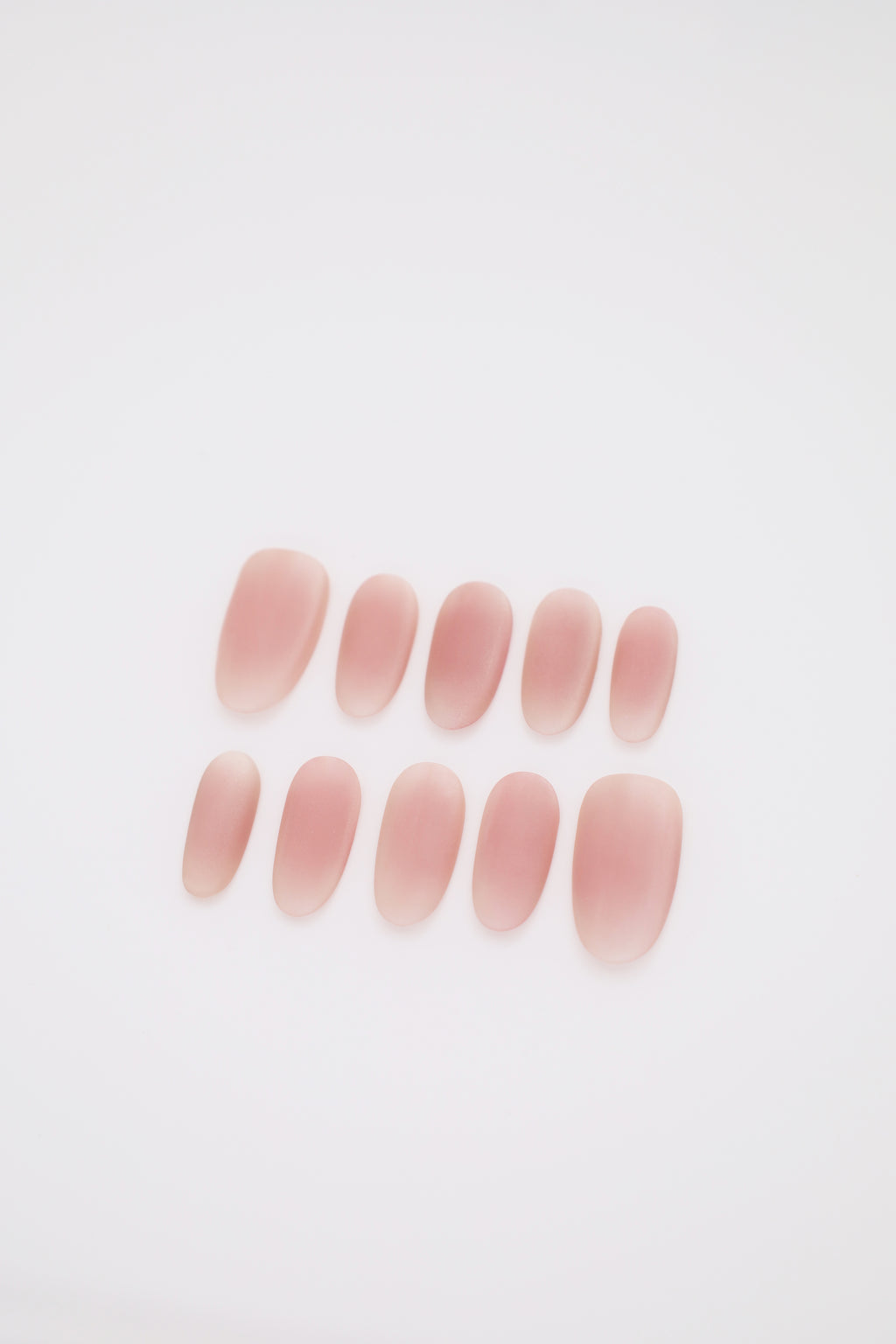 Blush Haze matte pink blush ombre oval press-on nails set display on dark background