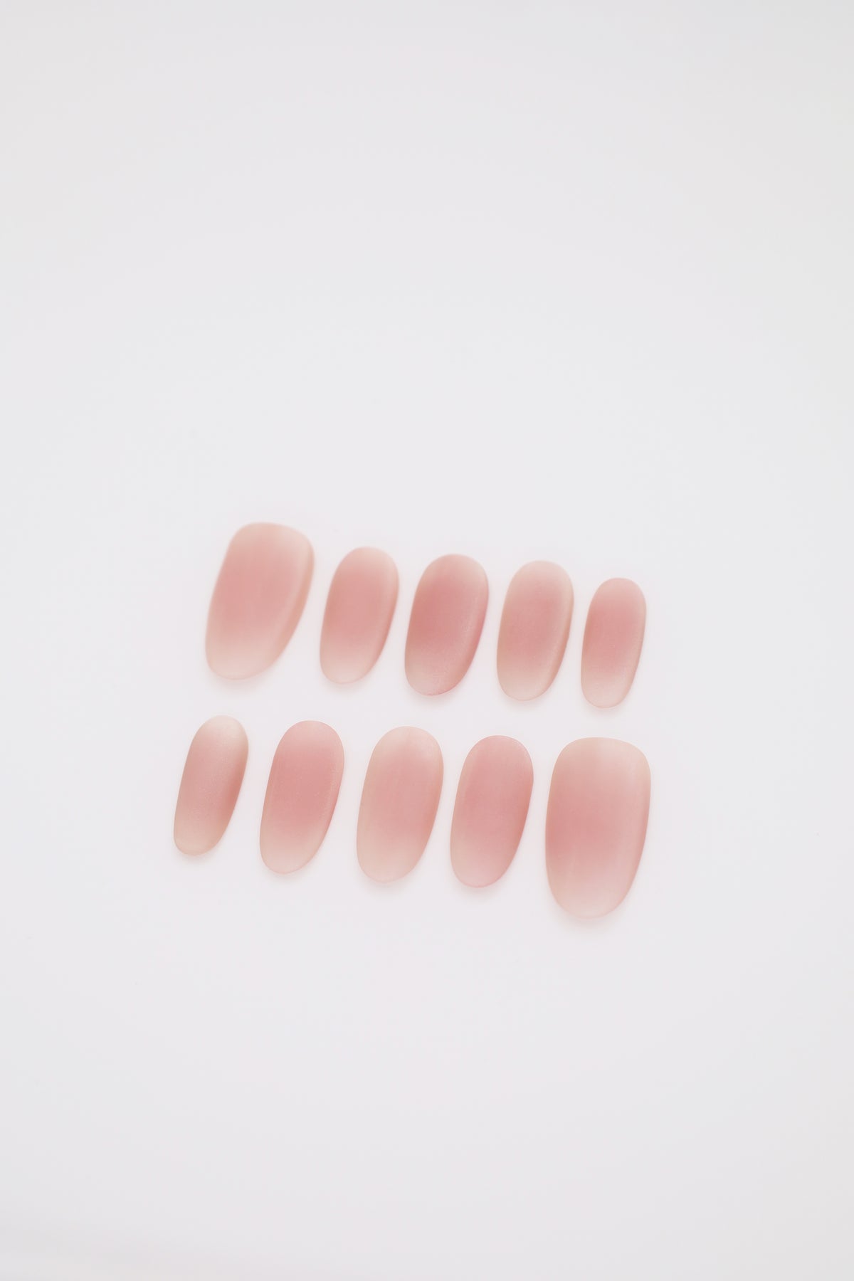 Blush Haze matte pink blush ombre oval press-on nails set display on dark background