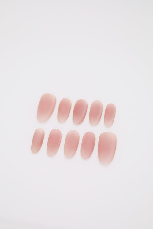 Blush Haze matte pink blush ombre oval press-on nails set display on dark background