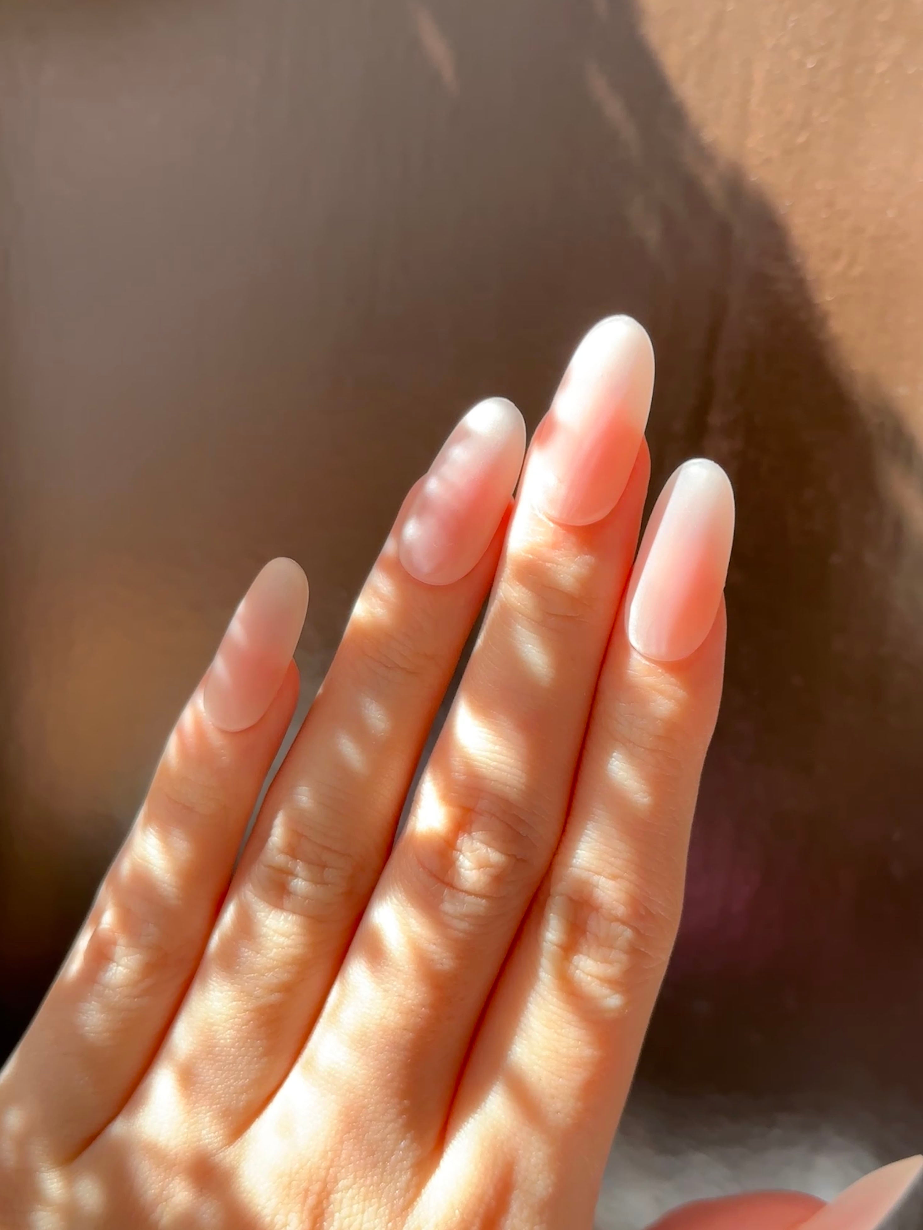 Blush Haze matte pink blush ombre press-on nails oval shape on hand