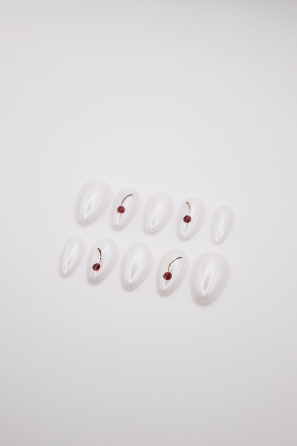 Frost Berry pearlescent white cherry press-on nails set flatlay display