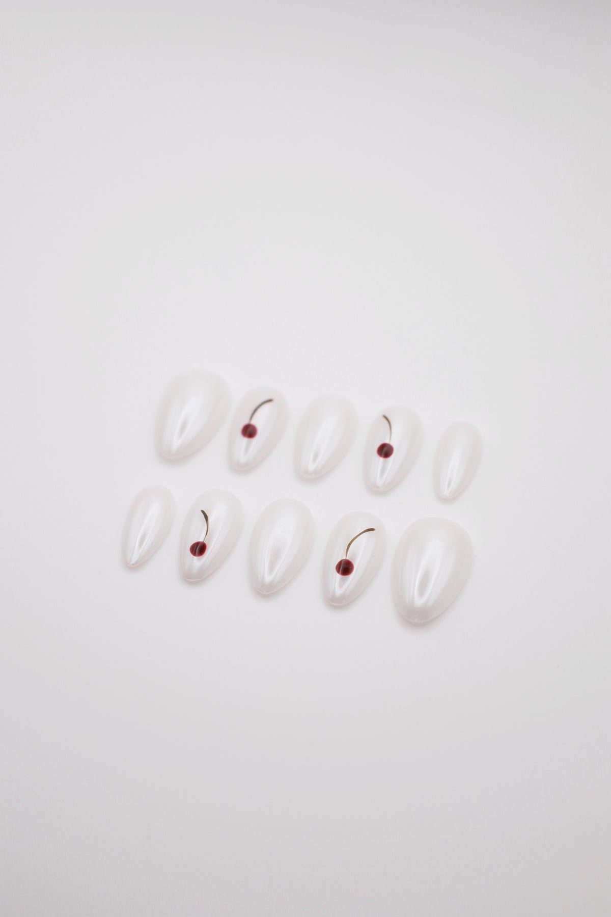 Frost Berry pearlescent white cherry press-on nails set flatlay display