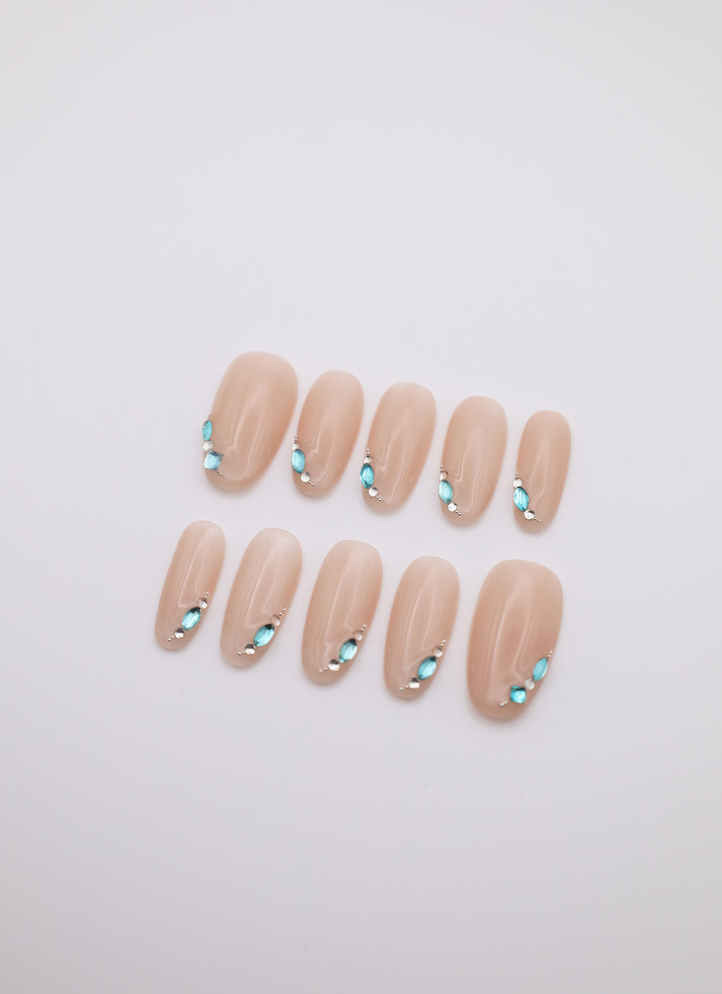 Mist Gem short oval nude press-on nails set with teardrop rhinestones flatlay display