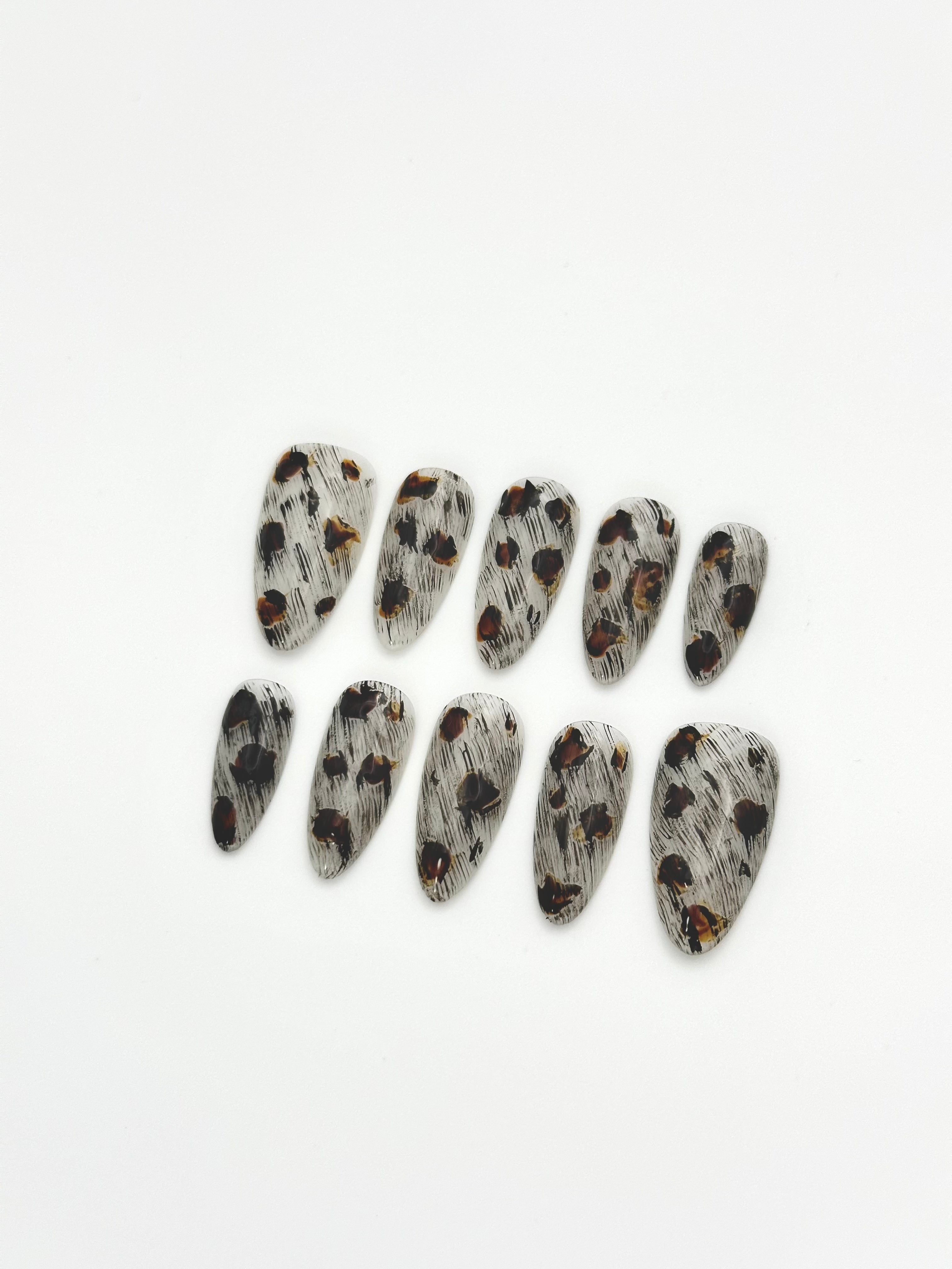 Sepia Dapple black and brown tortoiseshell almond press-on nails set flatlay display