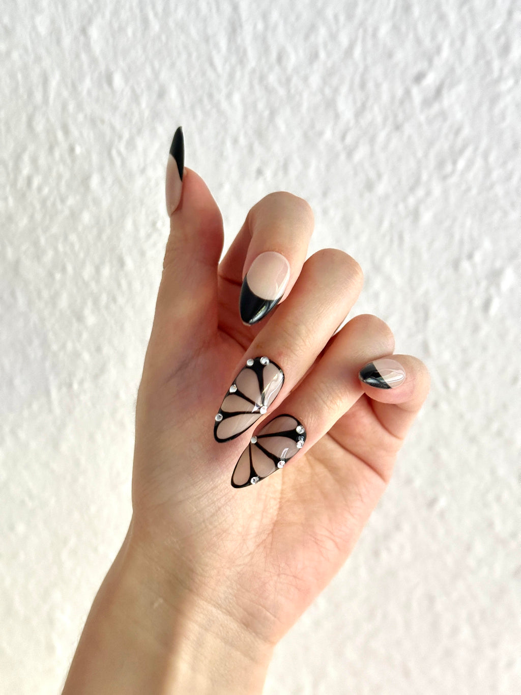 Hand wearing Shadow Wings black butterfly almond press-on nails