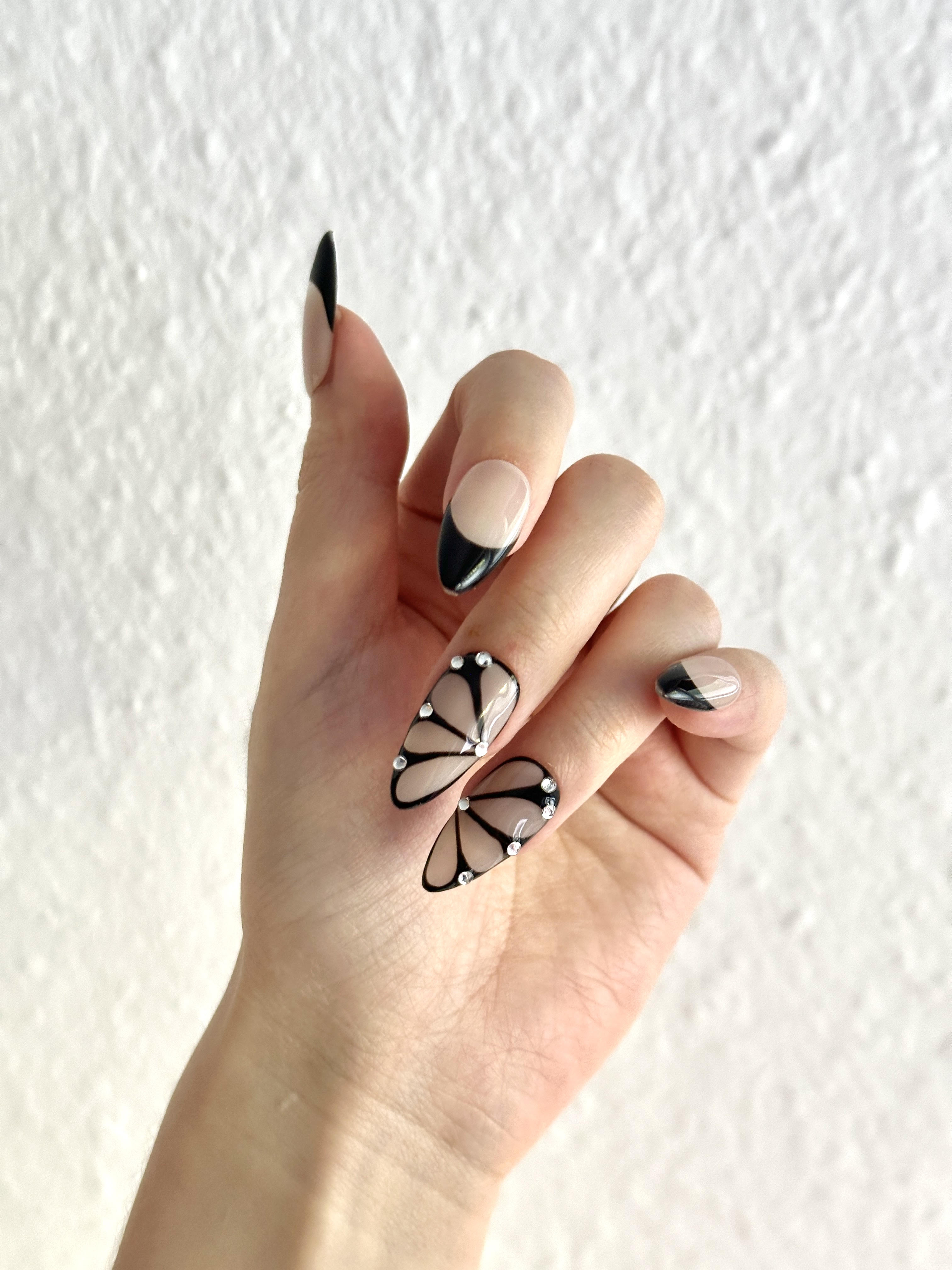 Hand wearing Shadow Wings black butterfly almond press-on nails