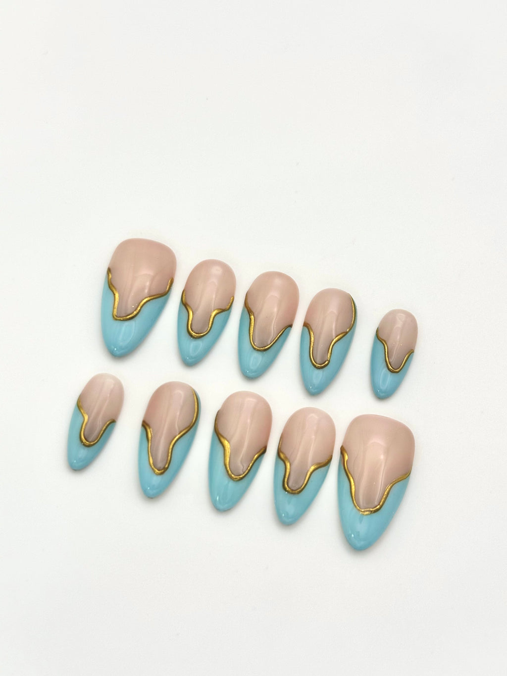 Sky Gild sky blue and gold wavy French almond press-on nails set flatlay display