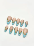 Sky Gild sky blue and gold wavy French almond press-on nails set flatlay display